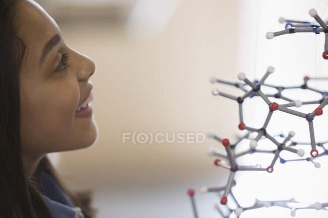 Chica curiosa estudiante examinando la estructura molecular - foto de stock