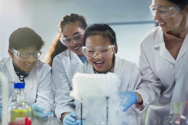 Цікаві, усміхнені студенти дивляться хімічну реакцію, проводячи науковий експеримент у лабораторних класах — стокове фото