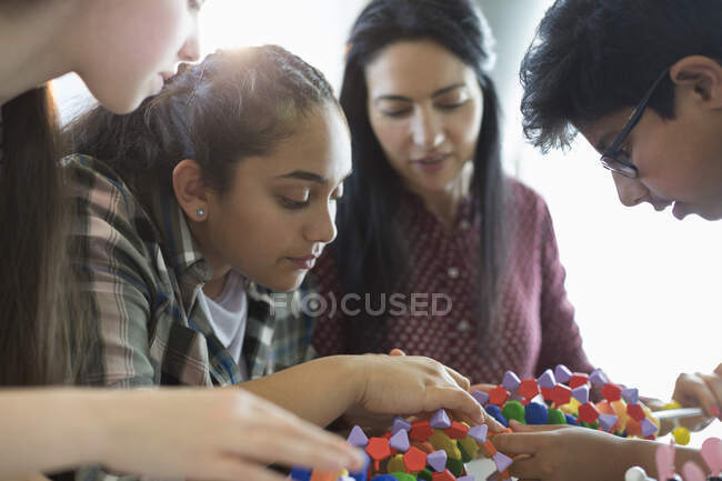 Curious students examining DNA model in classroom — Stock Photo