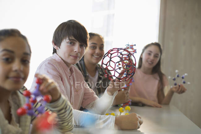 Retrato estudantes confiantes segurando estruturas moleculares em sala de aula de laboratório — Fotografia de Stock