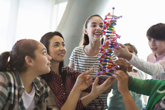 Жіночий учитель і студенти вивчають ДНК у класі. — стокове фото