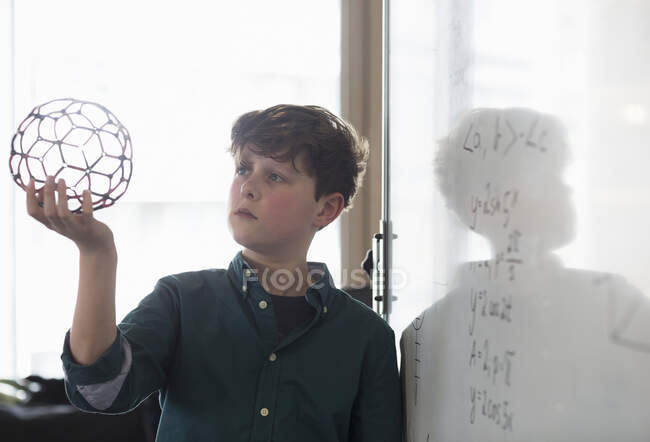 Серйозна студентка-хлопчик тримає молекулярну структуру в класі — стокове фото