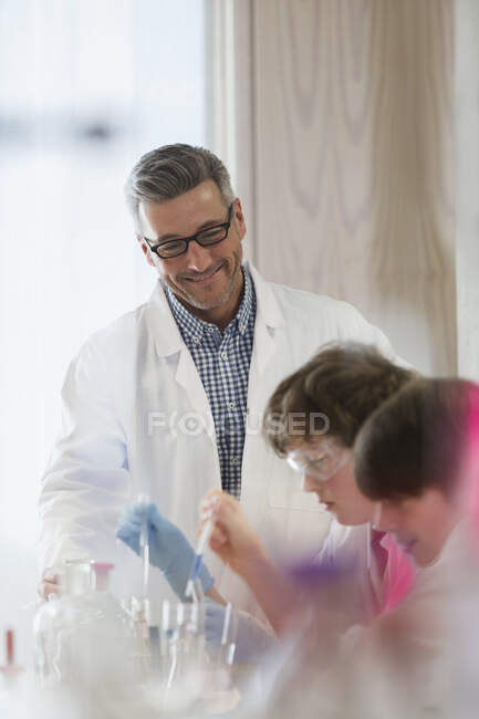 Male teacher and boy student conducting scientific experiment in laboratory classroom — Stock Photo