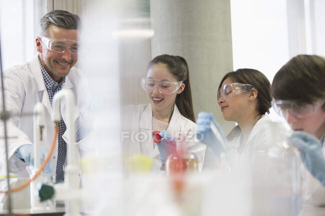 Учитель и ученики мужского пола проводят научные эксперименты в лабораторном классе — стоковое фото