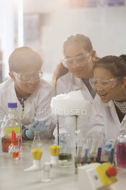 Sorprendió a los estudiantes que realizan experimentos científicos, viendo la reacción química en el laboratorio del aula - foto de stock
