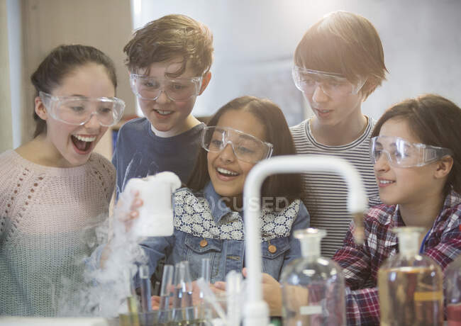 Здивовані студенти, які проводять науковий експеримент, спостерігають хімічну реакцію в лабораторії класу — стокове фото