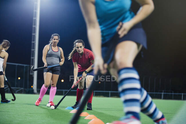 Young female field hockey players practicing sports drill on field — Stock Photo