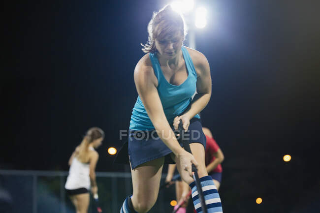 Determined young female field hockey player practicing sports drill — Stock Photo