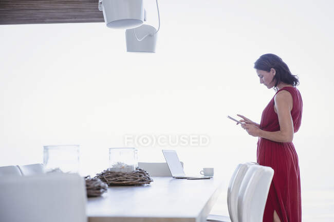 Mulher usando tablet digital, trabalhando na mesa da sala de jantar — Fotografia de Stock