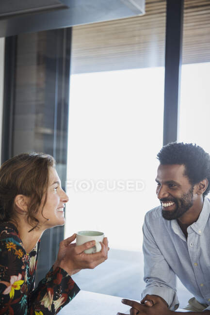 Multi-ethnic couple drinking coffee and talking — Stock Photo