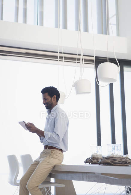 Businessman using digital tablet at dining table — Stock Photo