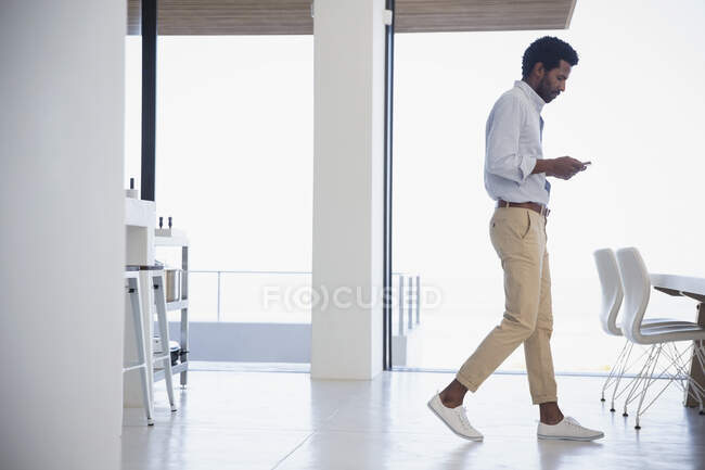 Homme d'affaires textos, marche dans la salle à manger — Photo de stock