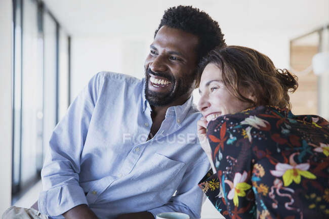 Sonriente, entusiasta pareja multiétnica mirando hacia otro lado - foto de stock