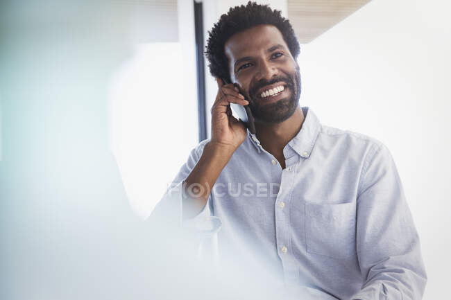 Hombre de negocios sonriente hablando por teléfono celular - foto de stock