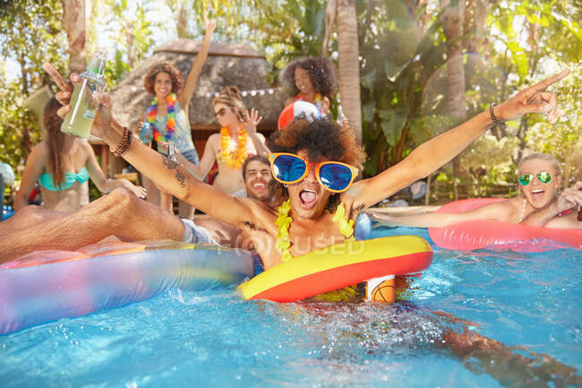 Retrato exuberante jovens amigos bebendo e brincando na piscina de verão — Fotografia de Stock