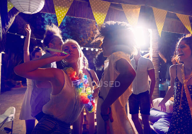 Jeunes amis avec des faveurs de fête dansant et traînant à la fête — Photo de stock
