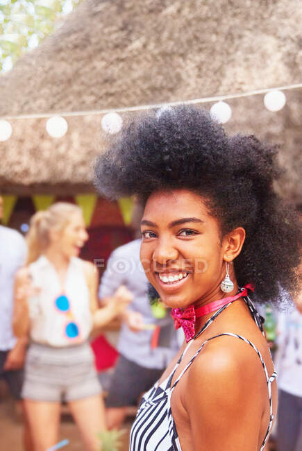 Уверенная в себе, улыбающаяся молодая женщина на летней вечеринке — стоковое фото