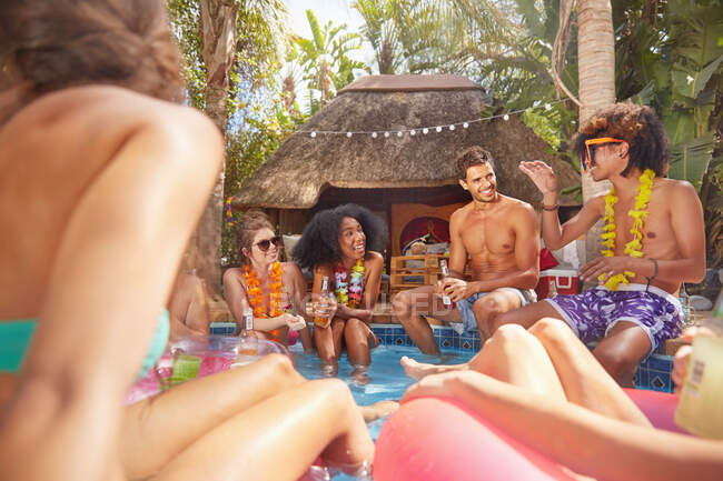 Молодые друзья тусуются в солнечном летнем бассейне — стоковое фото