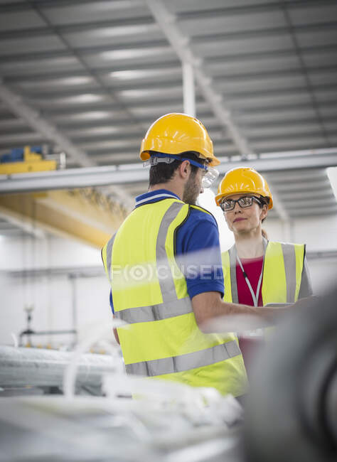 Рабочие разговаривают на заводе — стоковое фото