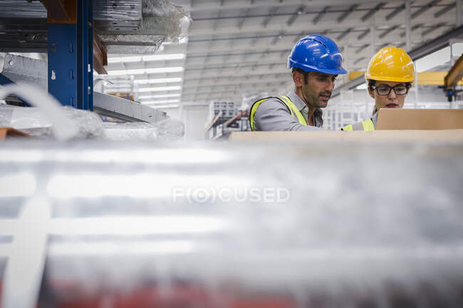 Managers using laptop in factory — Stock Photo