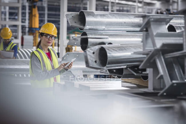 Porträt selbstbewusste Arbeiterin mit digitalem Tablet in Stahlfabrik — Stockfoto