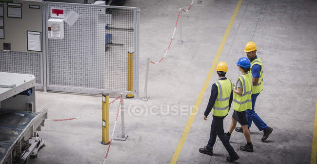 Arbeiter gehen und reden in Fabrik — Stockfoto