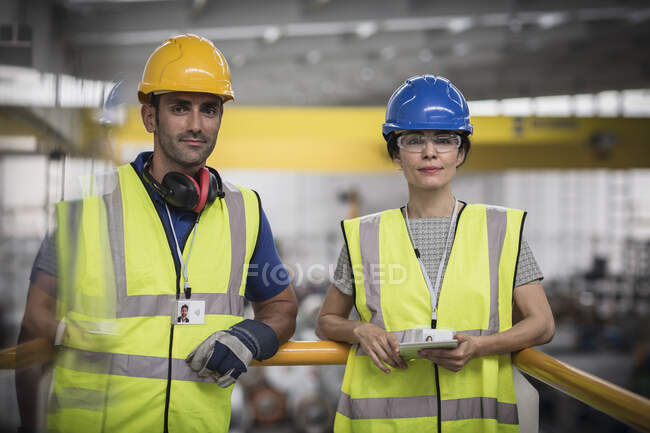 Portrait confident supervisors with digital tablet on platform in factory — Stock Photo