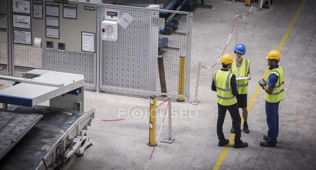 Supervisor e trabalhadores conversando na fábrica — Fotografia de Stock