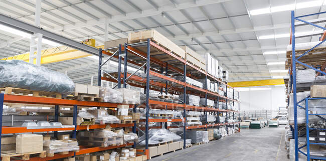 Pallets and equipment on shelves in warehouse — Stock Photo