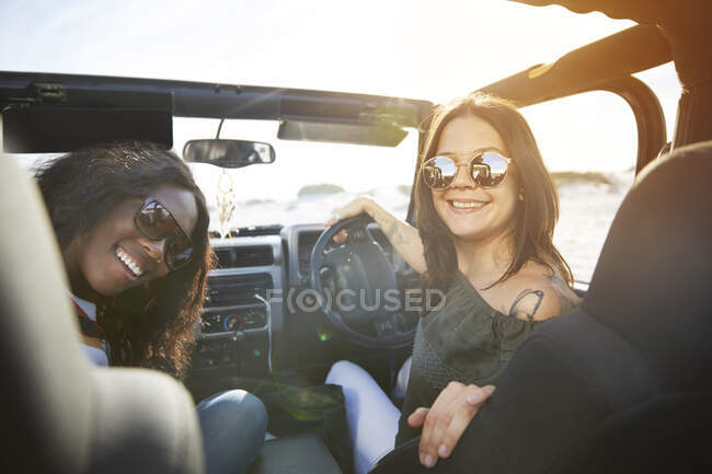 Портрет усміхнених молодих жінок друзів у сонцезахисних окулярах у сонячному джипі — стокове фото