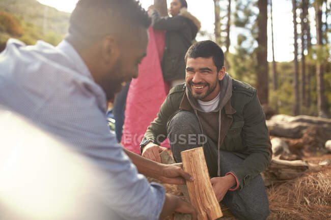 Freunde junger Männer bauen Lagerfeuer auf Campingplatz — Stockfoto