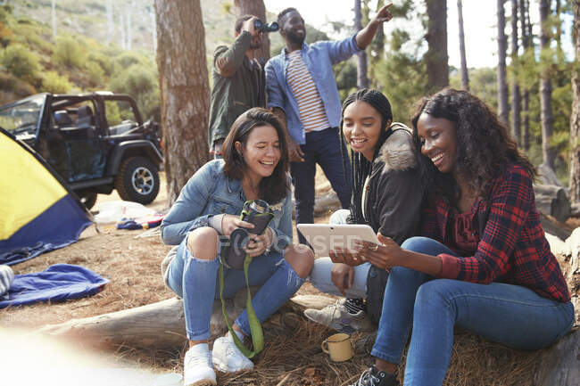 Усміхнені молоді жінки друзі використовують цифровий планшет на кемпінгу — стокове фото