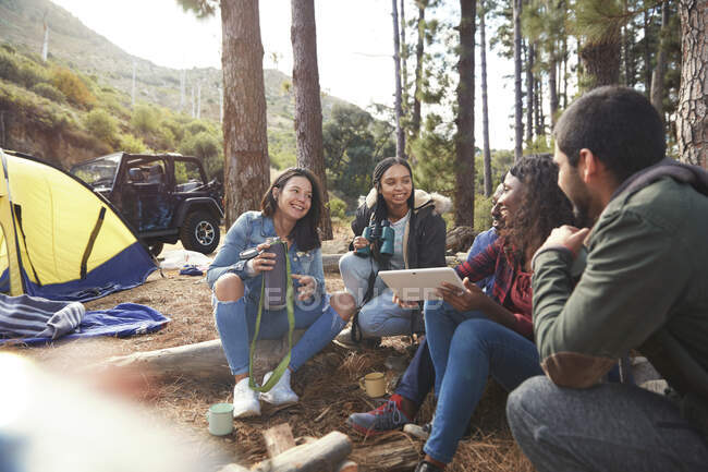 Jeunes amis avec tablette numérique traînant au camping — Photo de stock