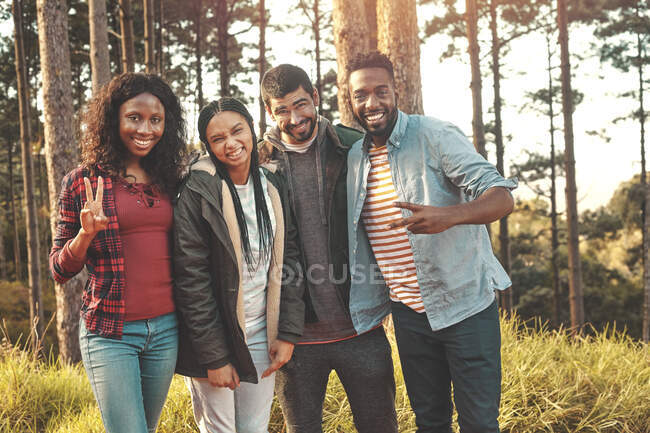 Porträt selbstbewusste junge Freunde gestikulieren mit Friedenszeichen im Wald — Stockfoto