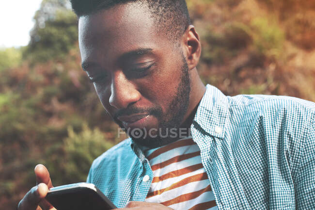 Junger Mann schreibt SMS mit Handy — Stockfoto