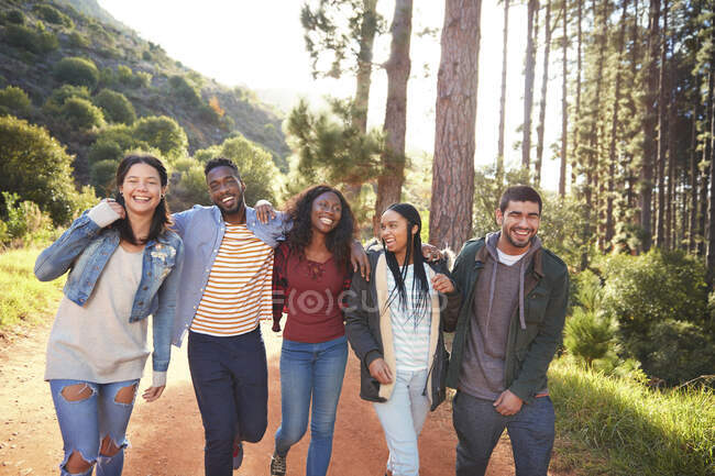 Young friends walking in a row in woods — Stock Photo