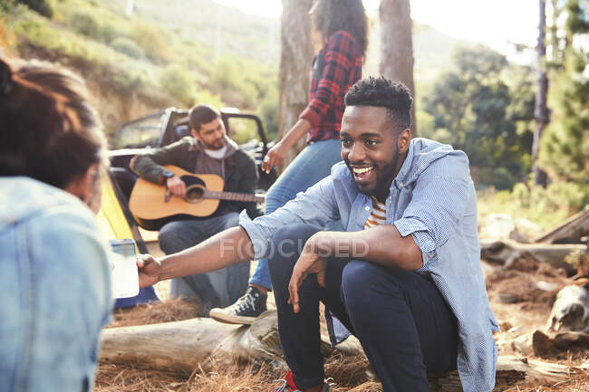 Jeune homme et ses amis traînant au camping — Photo de stock