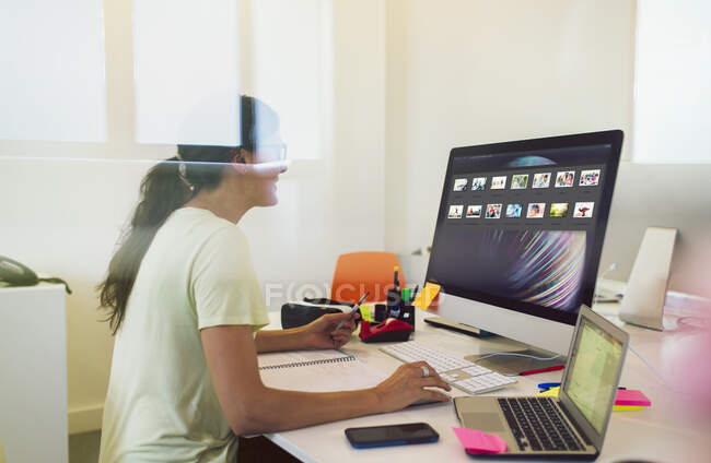 Designer femminile che visualizza miniature immagine sul computer in ufficio — Foto stock