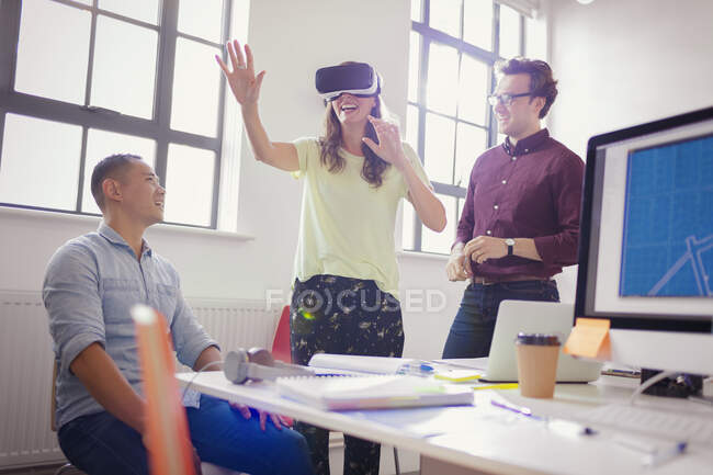 Des programmeurs informatiques enthousiastes testent des lunettes de simulateur de réalité virtuelle au bureau — Photo de stock