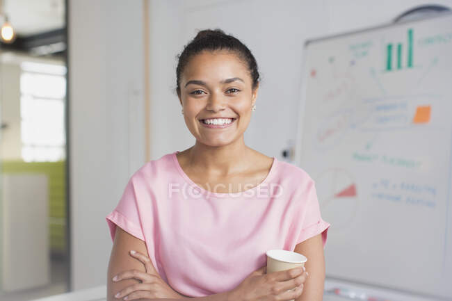 Portrait femme d'affaires confiante et enthousiaste au tableau blanc dans la salle de conférence — Photo de stock