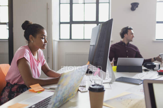 Focused female designer working at computer in office — Stock Photo
