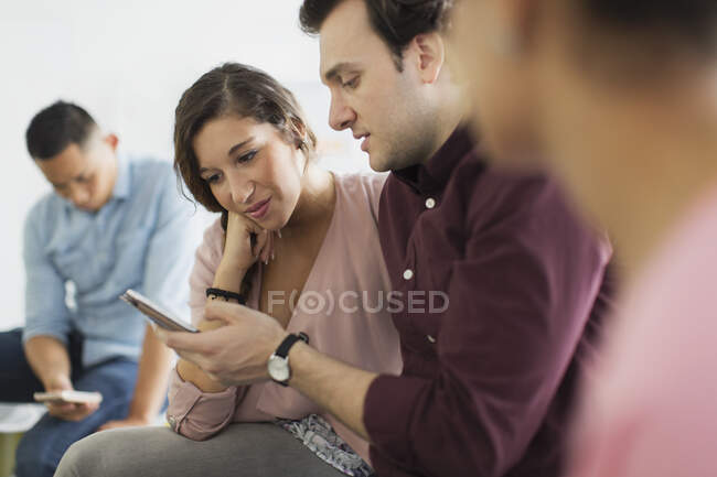 Businessman showing digital tablet to businesswoman in meeting — Stock Photo