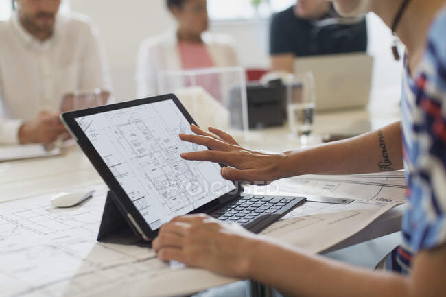 Female architect viewing digital blueprint on touch screen digital tablet — Stock Photo