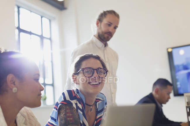 Улыбающаяся, уверенная в себе деловая женщина за ноутбуком в конференц-зале — стоковое фото