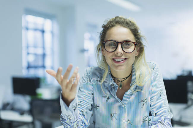 Portrait smiling, confident, gesturing businesswoman in office — Stock Photo