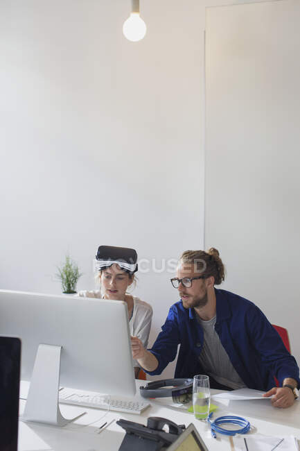 Computer programmers programming virtual reality simulator glasses at computer in office — Stock Photo