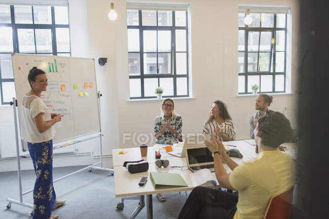 Female designer at whiteboard leading conference room meeting — Stock Photo