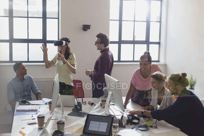 Programadores de computador programando óculos de simulador de realidade virtual em escritório em plano aberto — Fotografia de Stock