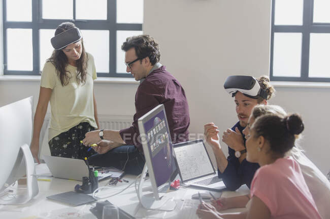 Computer programmers programming virtual reality simulator glasses in office — Stock Photo