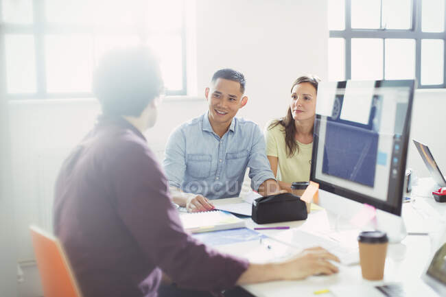 Designers talking, working at computer in office — Stock Photo